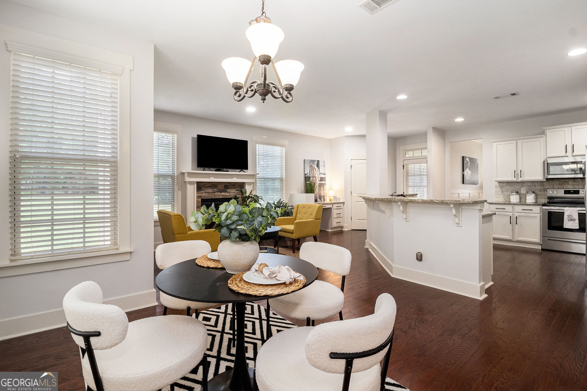 466 Austin Storey Circle Newnan, GA 30263 - Photo 7 of 38 a view of a dining room with furniture a chandelier and wooden floor