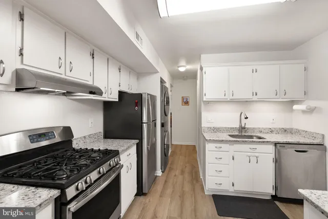 a kitchen with stainless steel appliances granite countertop a sink stove and cabinets