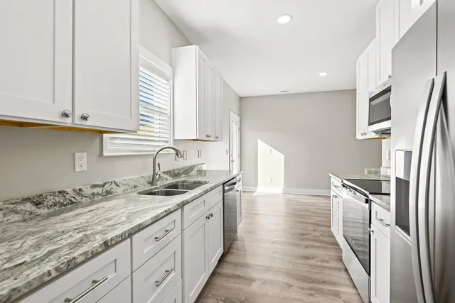 a kitchen with granite countertop a sink and cabinets