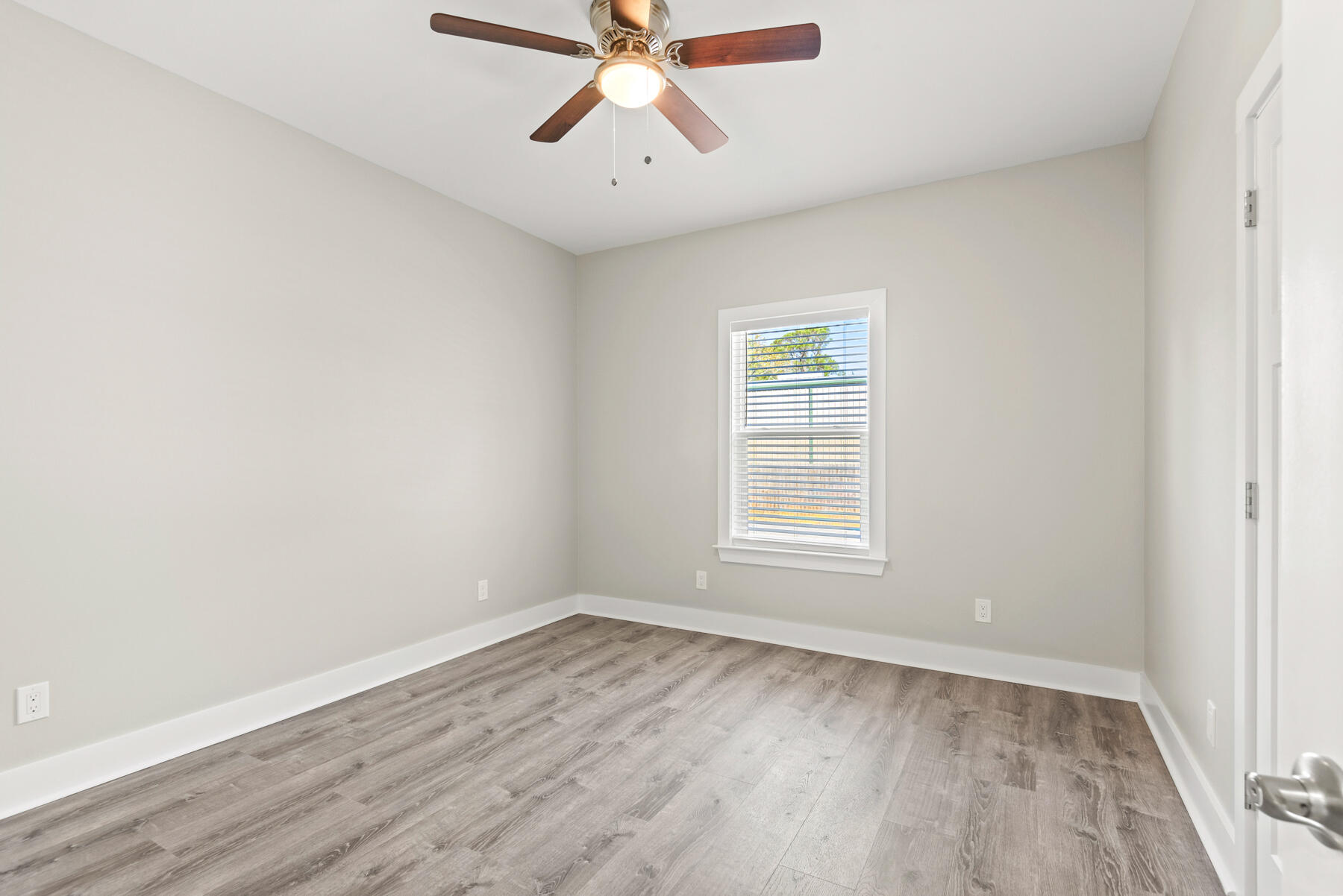 46 Winfield Street Niceville, FL 32578 - Photo 20 of 32 an empty room with wooden floor chandelier fan and windows
