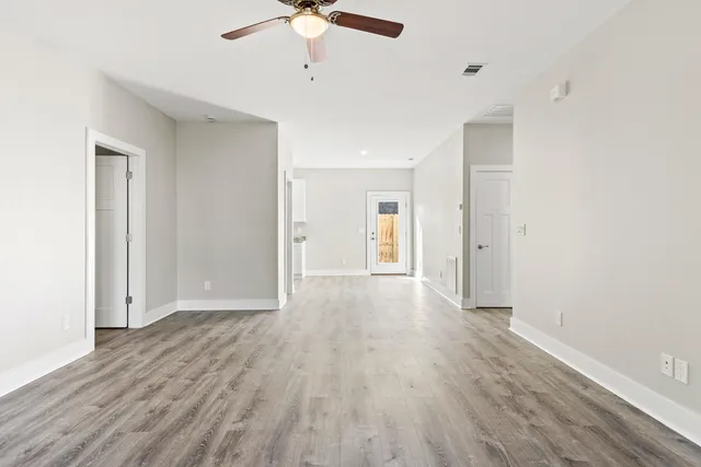 a view of an empty room with wooden floor