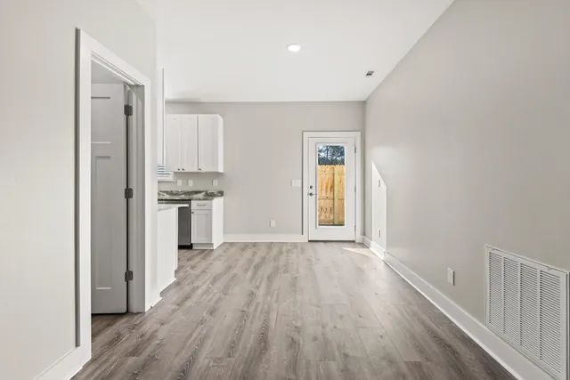 a view of wooden floor and a kitchen in a room