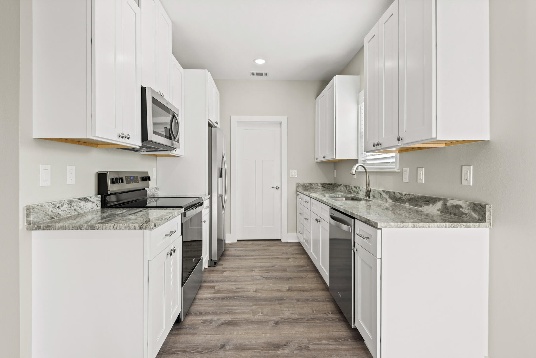 46 Winfield Street Niceville, FL 32578 - Photo 10 of 32 a kitchen with stainless steel appliances granite countertop a stove top oven a sink a refrigerator and white cabinets