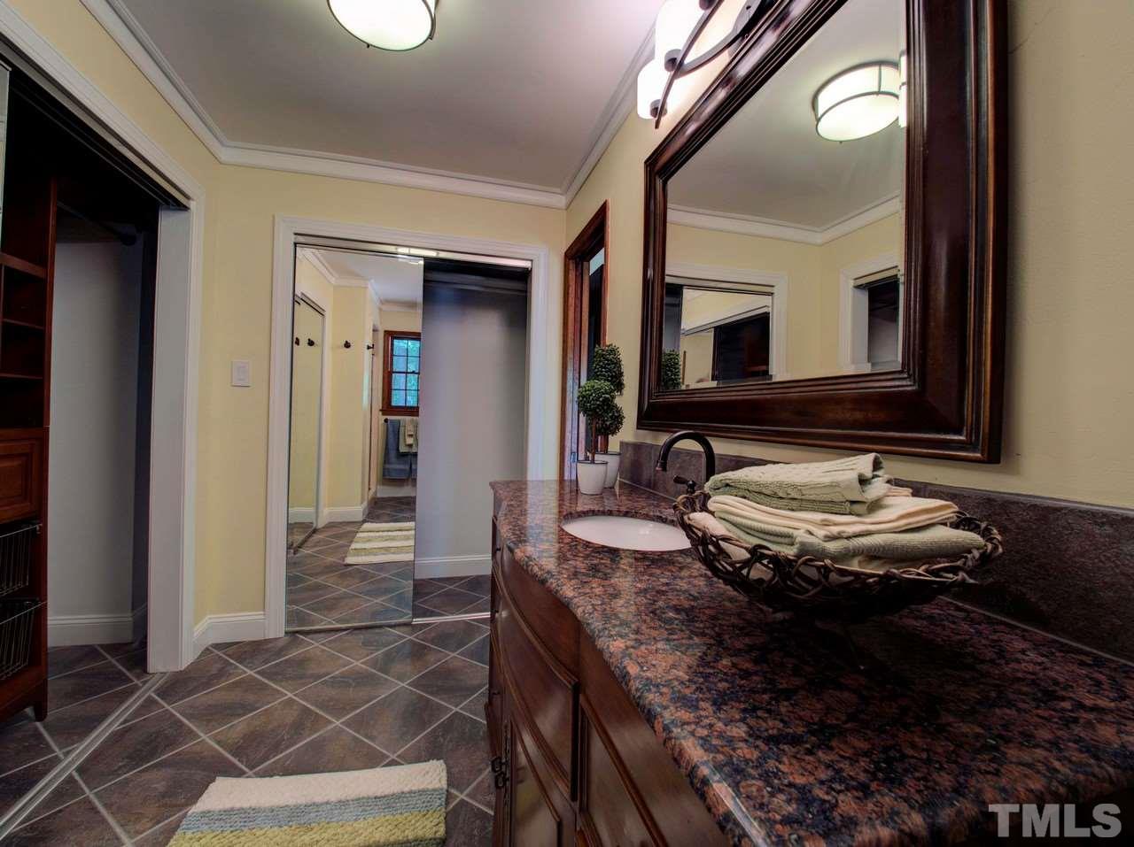 8316 Heel Stone Court Raleigh, NC 27613 - Photo 18 of 25 a bathroom with a granite countertop sink and a mirror