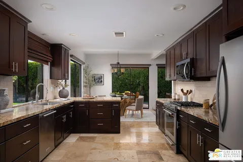 a large kitchen with kitchen island granite countertop a large counter top stainless steel appliances and cabinets