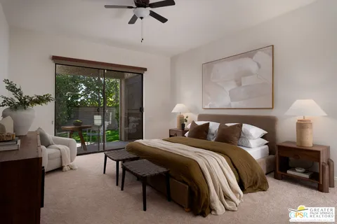 a bedroom with a bed large window couch and a balcony