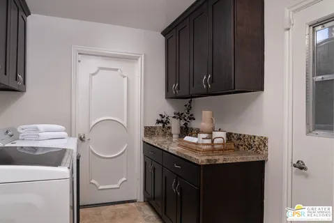 a bathroom with a granite countertop sink and a toilet