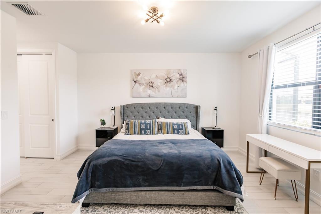 7536 Carnegie Way Naples, FL 34119 - Photo 11 of 23 a bedroom with a large bed and a window