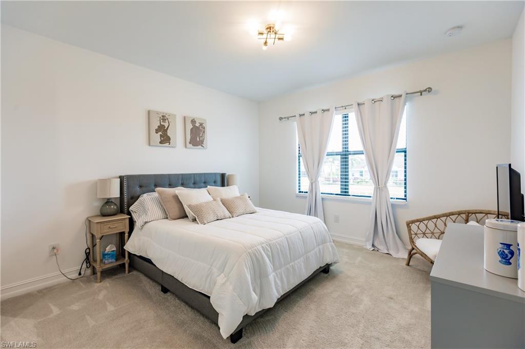 7536 Carnegie Way Naples, FL 34119 - Photo 15 of 23 a bedroom with a bed and a table