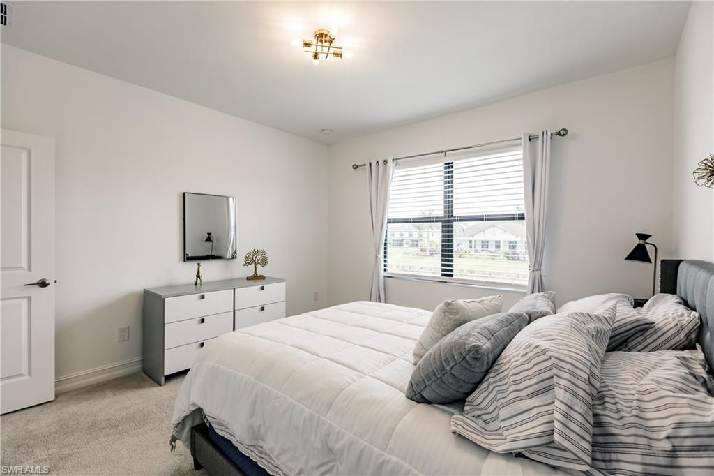 7536 Carnegie Way Naples, FL 34119 - Photo 18 of 23 a bedroom with a bed and a table