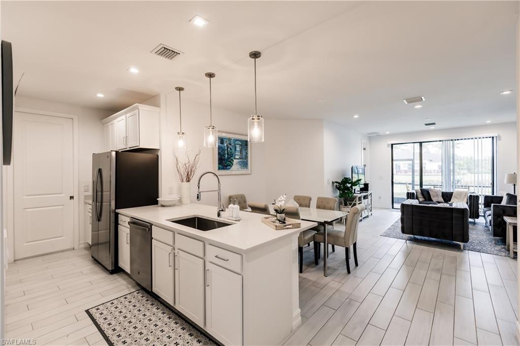 7536 Carnegie Way Naples, FL 34119 - Photo 2 of 23 a kitchen that has a lot of cabinets a sink and appliances in it