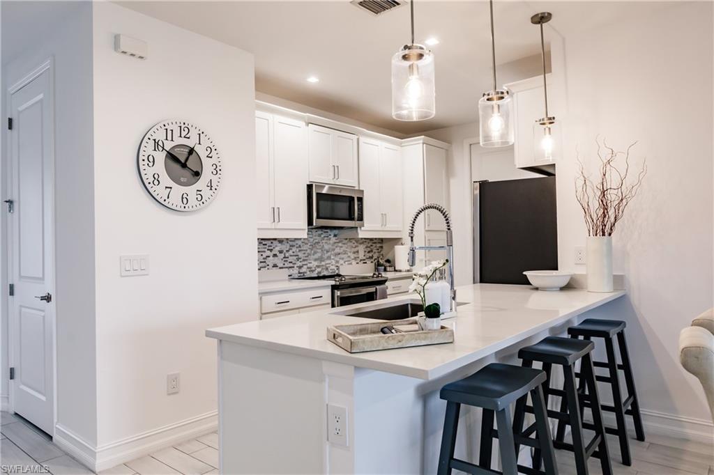 7536 Carnegie Way Naples, FL 34119 - Photo 3 of 23 a kitchen with stainless steel appliances granite countertop a stove and a refrigerator