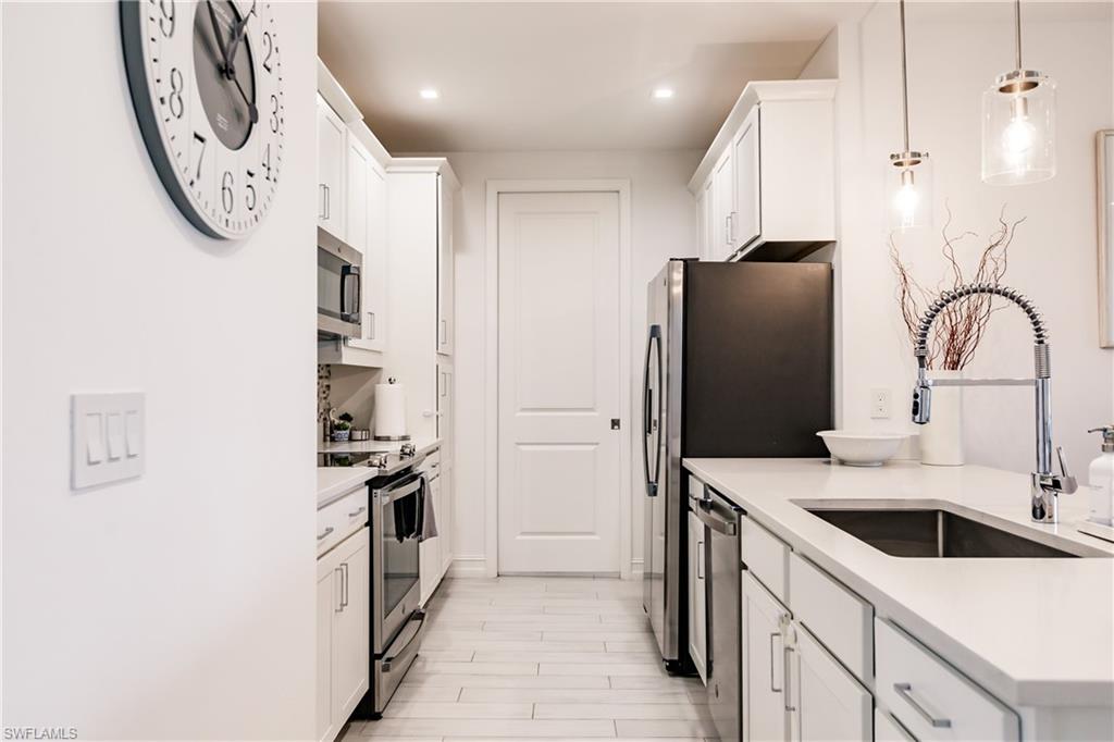 7536 Carnegie Way Naples, FL 34119 - Photo 4 of 23 a kitchen with stainless steel appliances a refrigerator sink and cabinets