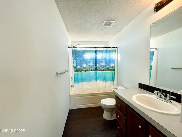 a bathroom with a sink a toilet and a large mirror