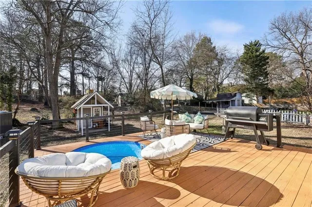 a view of roof deck with couches wooden floor and fence