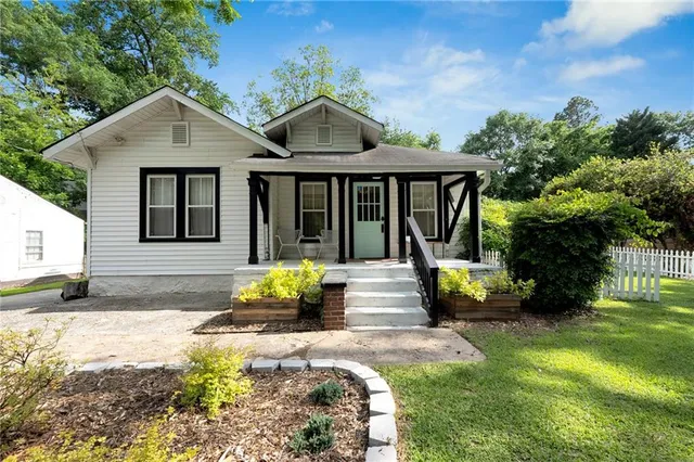 a view of a house with backyard and sitting area