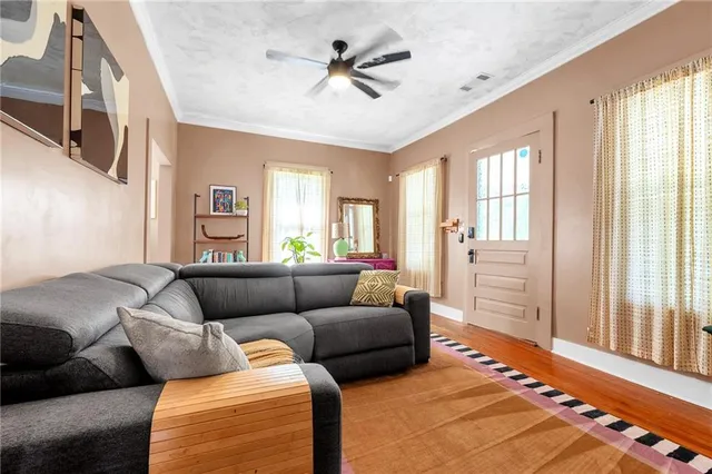 a living room with furniture a flat screen tv and a large window