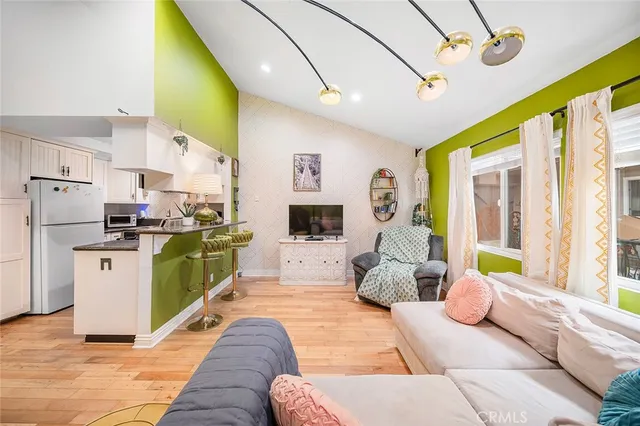 a living room with furniture kitchen view and a large window