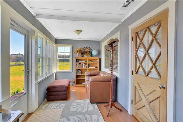 a view of a a dining room with furniture window and wooden floor