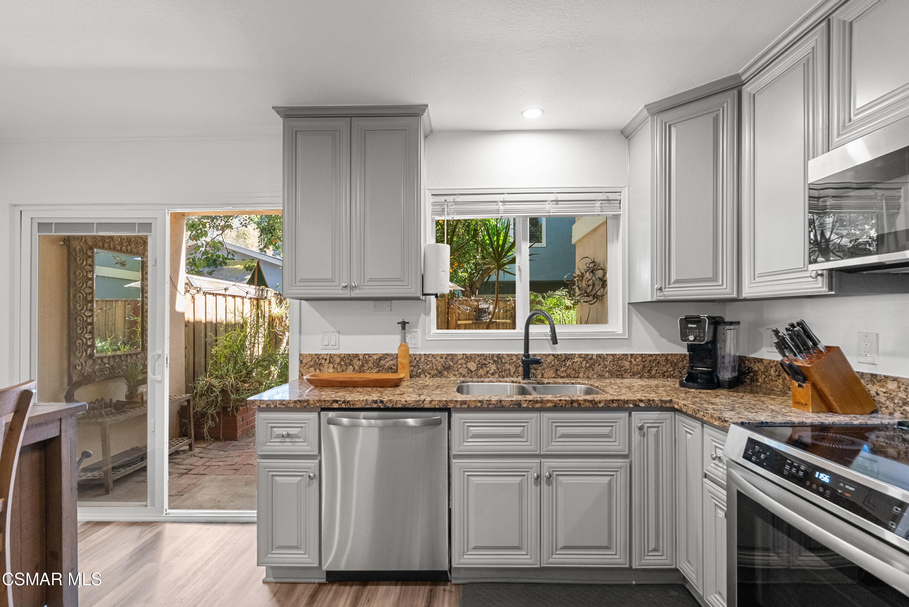30535 Canwood Street, Unit R58 Agoura Hills, CA 91301 - Photo 6 of 23 a kitchen with granite countertop a sink stainless steel appliances and cabinets