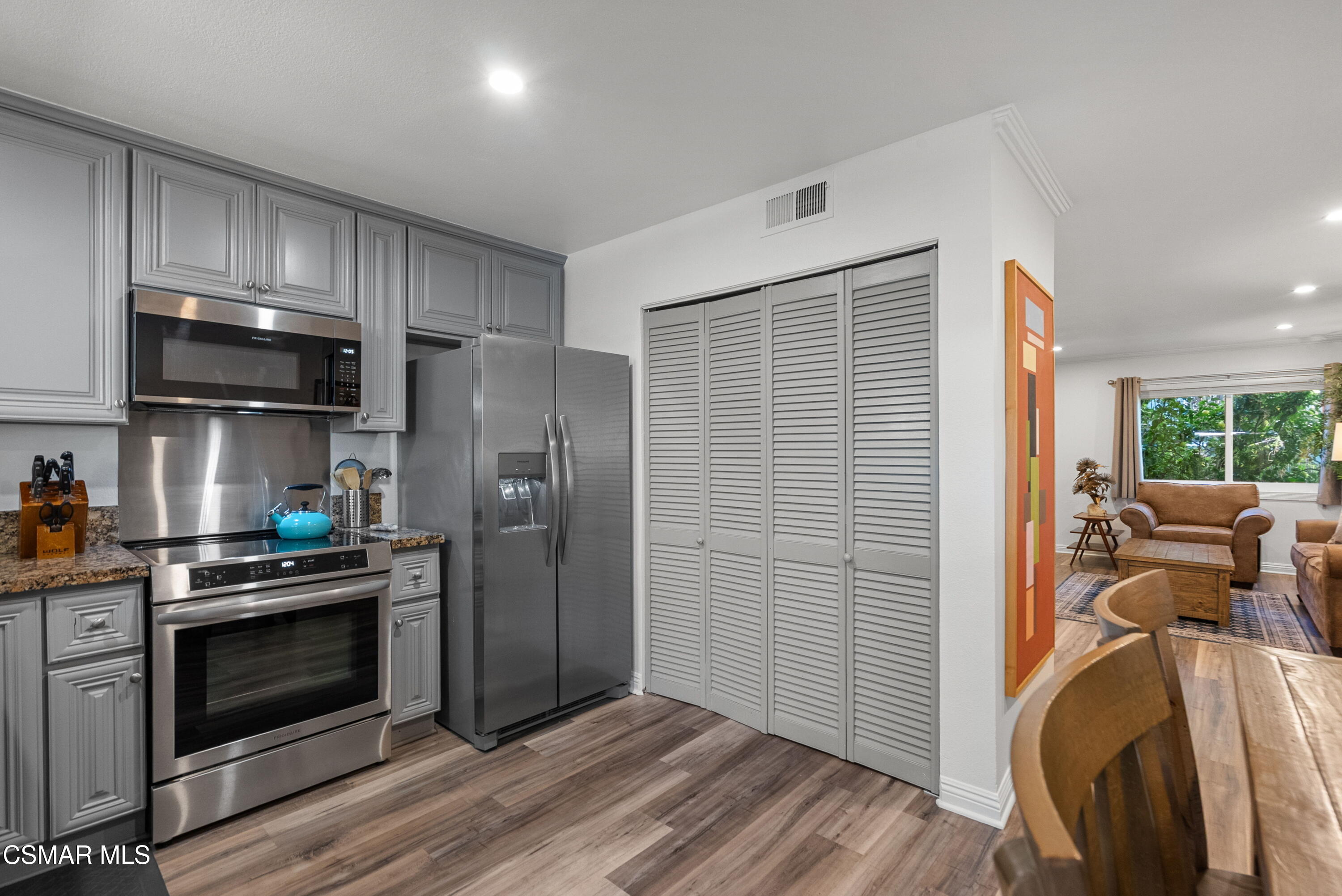 30535 Canwood Street, Unit R58 Agoura Hills, CA 91301 - Photo 8 of 23 a kitchen with stainless steel appliances a stove a refrigerator cabinets and a wooden floor