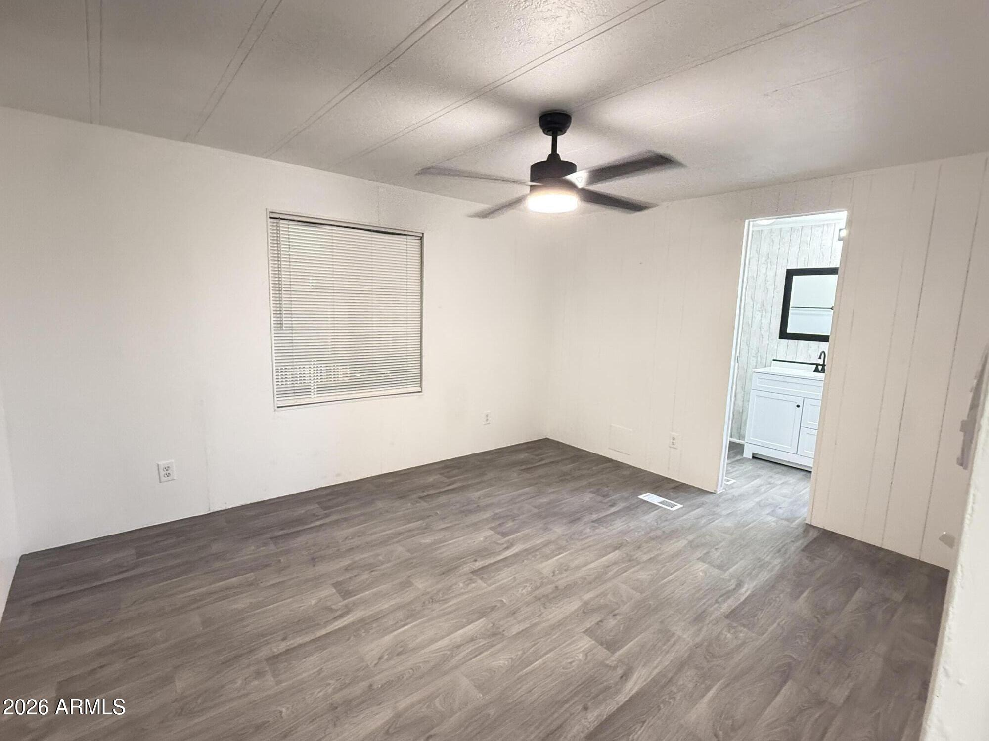 535 South Alma School Road, Unit 113 Mesa, AZ 85210 - Photo 15 of 41 an empty room with wooden floor ceiling fan and windows