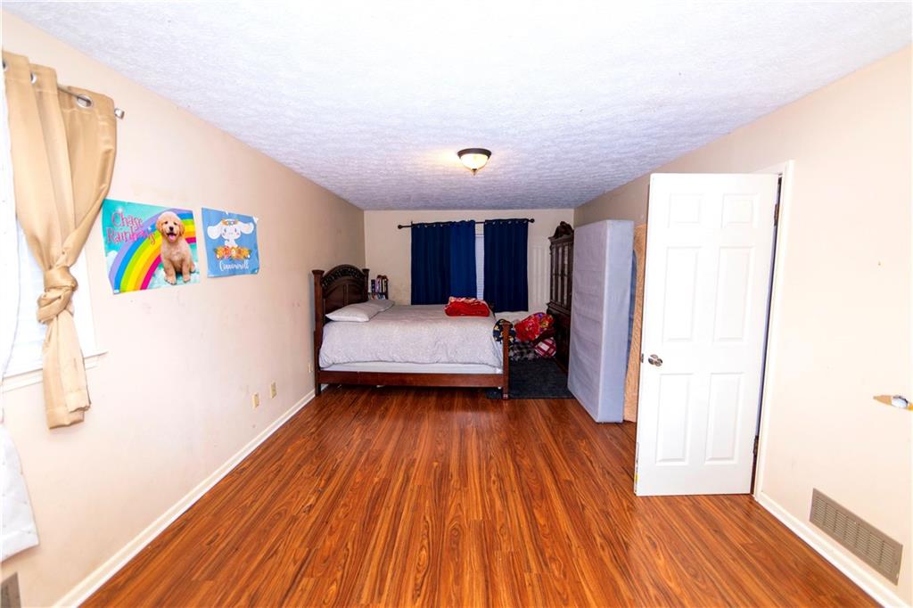 775 Shannon Way Lawrenceville, GA 30044 - Photo 19 of 24 a bedroom with a bed and a view of kitchen