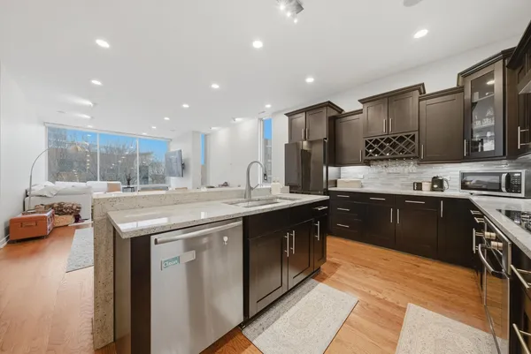 a kitchen with stainless steel appliances granite countertop a sink stove and cabinets