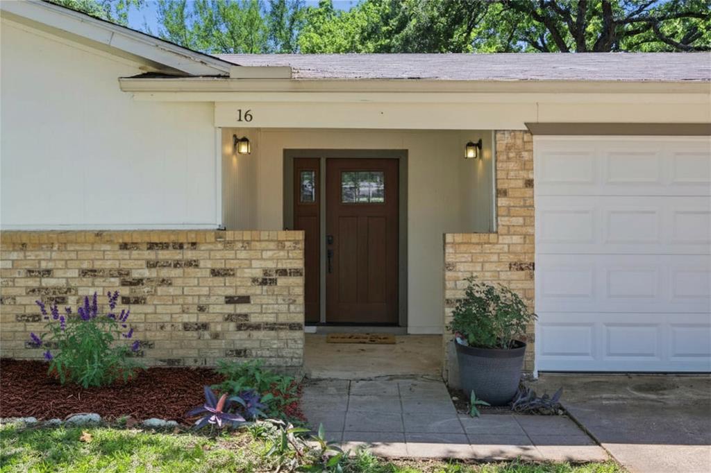 16 Coffee Tavern Road Bedford, TX 76022 - Photo 2 of 24 Property exterior featuring a paneled wood-finish entry door with glass inserts, brick facade, recessed entryway lighting, and a white garage door