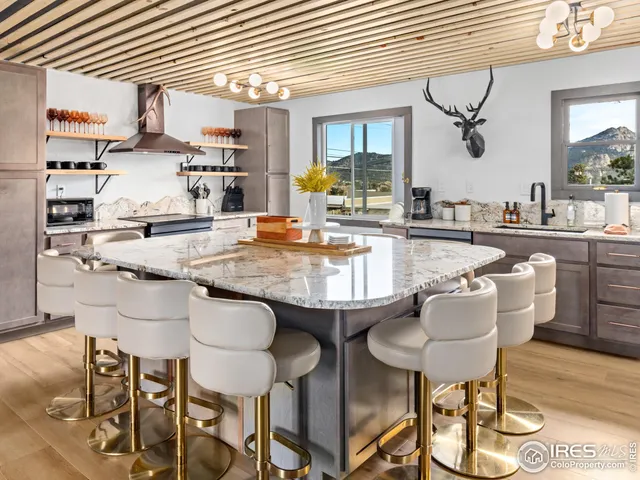 a kitchen with stainless steel appliances granite countertop table chairs and wooden floor