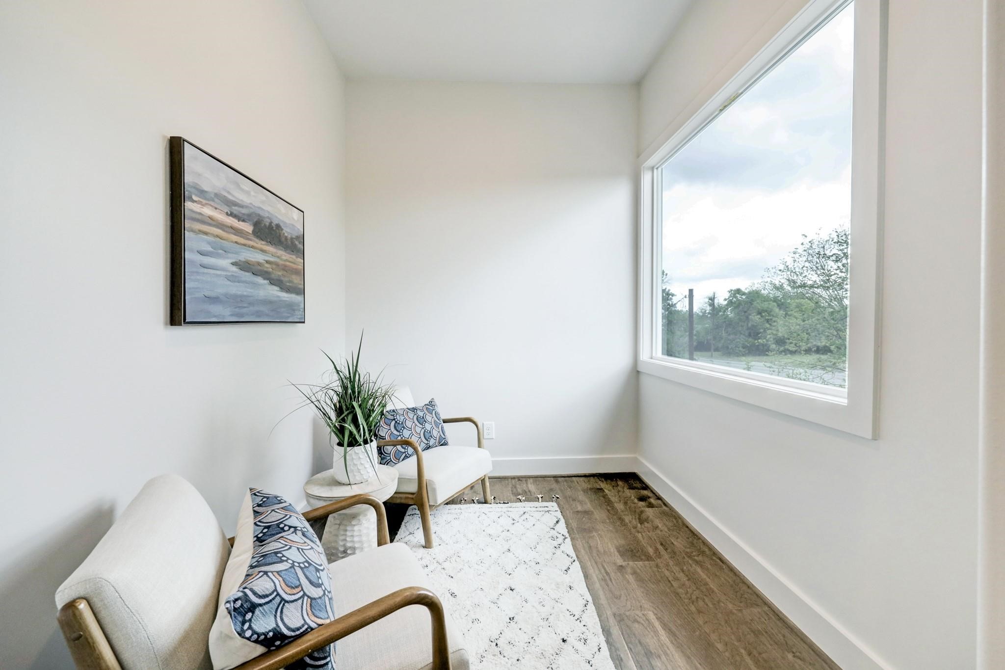3827 Arlington Street Houston, TX 77018 - Photo 20 of 39 This cozy nook features a large window offering a scenic view, and a serene painting on the wall. The space has a bright, airy ambiance with wood floors and neutral walls, ideal for relaxation or reading.