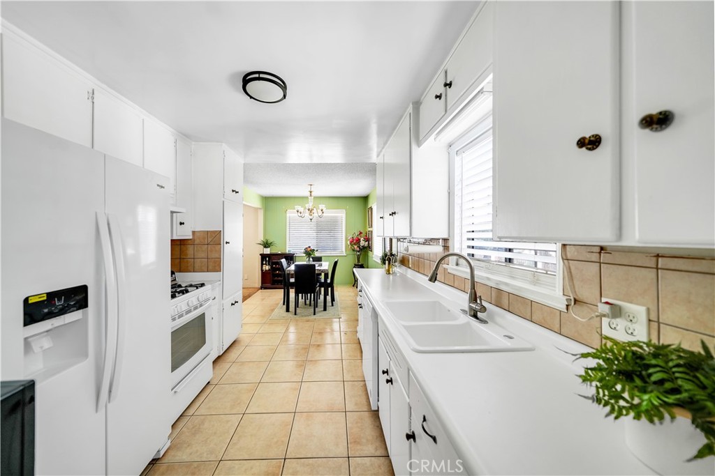 8201 Page Street Buena Park, CA 90621 - Photo 11 of 32 a large white kitchen with a sink and refrigerator
