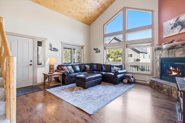 a kitchen with stainless steel appliances kitchen island granite countertop a refrigerator a stove a sink a dining table and chairs with wooden floor