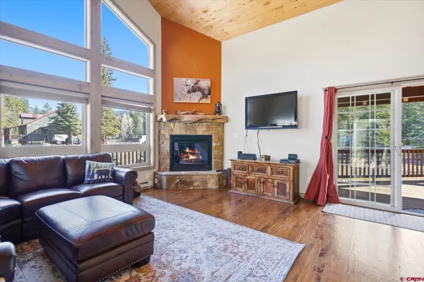 a kitchen with stainless steel appliances granite countertop wooden cabinets a sink a stove a dining table and chairs