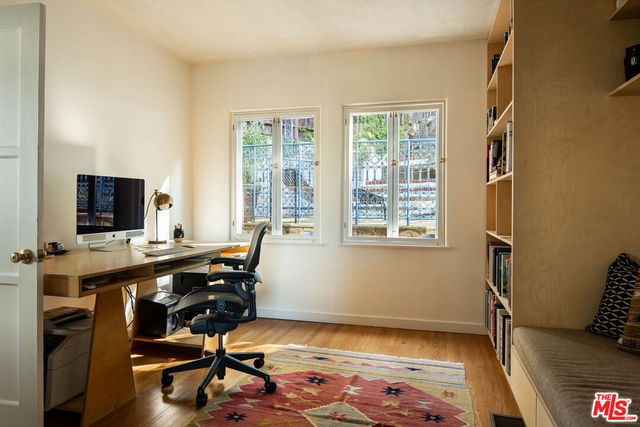 a view of a workspace with furniture and a window