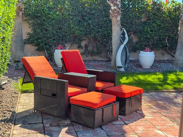 a view of a patio with table and chairs potted plants and a palm tree