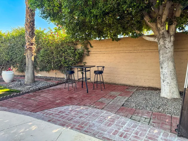 a view of a patio with table and chairs under an umbrella