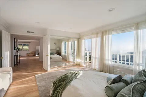 a bedroom with a bed and glass walk in closet