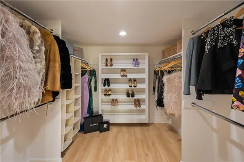 a large bed sitting in a bedroom next to a window with pc on dresser