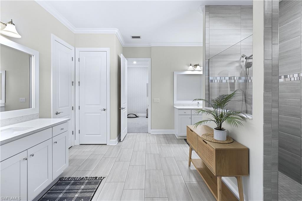 19074 Elston Way Estero, FL 33928 - Photo 28 of 50 a spacious bathroom with a double vanity sink and mirror