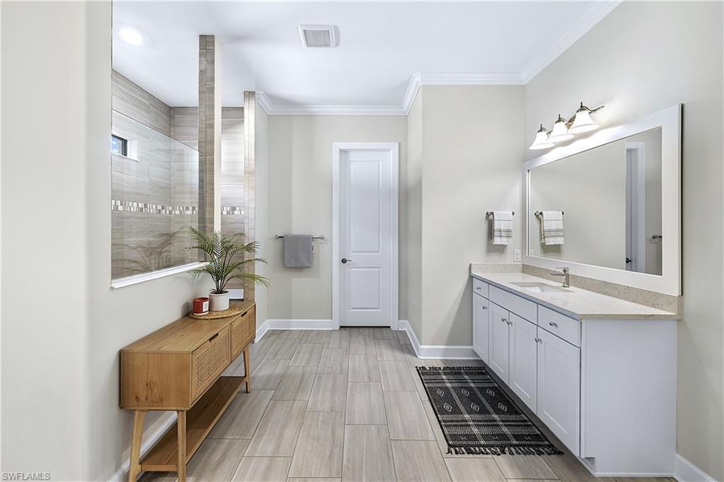 19074 Elston Way Estero, FL 33928 - Photo 30 of 50 a spacious bathroom with a double vanity sink a mirror and a shower