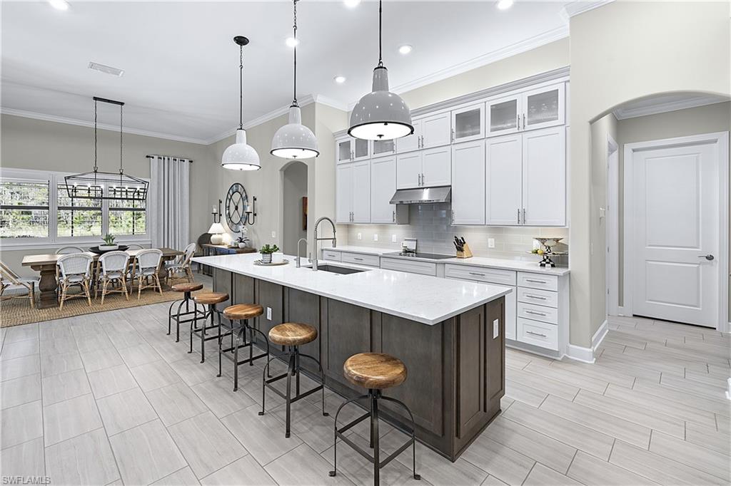 19074 Elston Way Estero, FL 33928 - Photo 34 of 50 a kitchen with stainless steel appliances kitchen island granite countertop a table chairs sink and cabinets