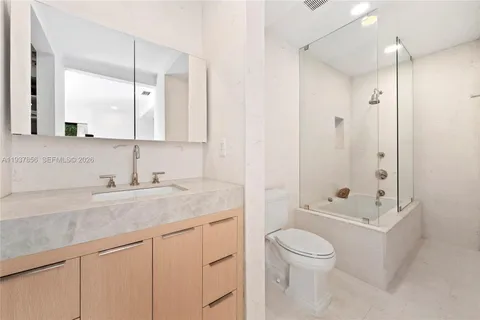 a bathroom with a granite countertop sink a toilet and shower