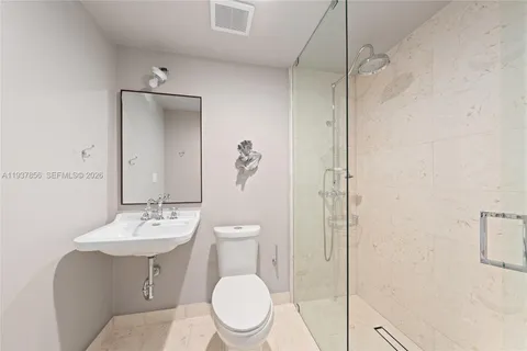 a white toilet sitting next to a bathroom sink