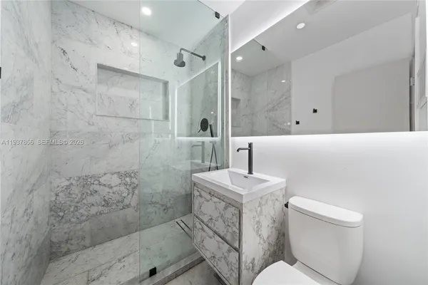 a bathroom with a sink a toilet and shower