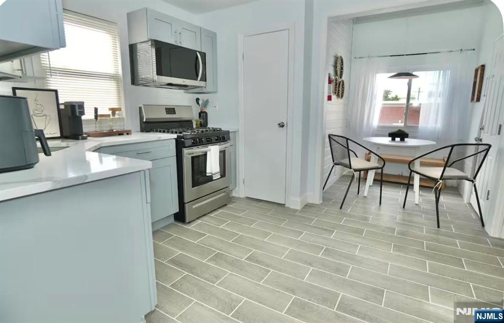 125 Malvern Street Newark, NJ 07105 - Photo 3 of 19 a kitchen with stainless steel appliances kitchen island granite countertop a sink and a microwave