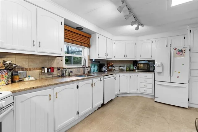 a kitchen with white cabinets and white appliances