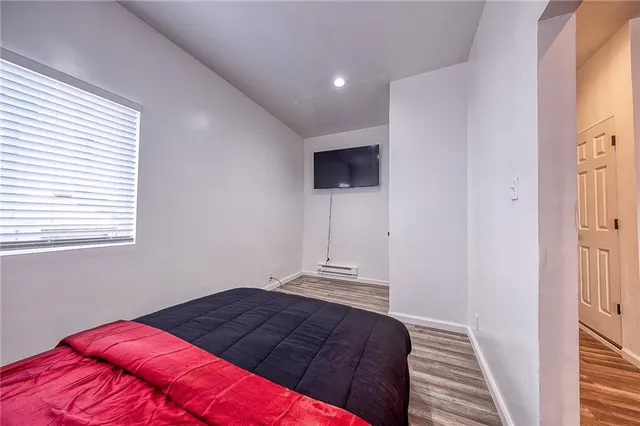 a bedroom with a bed and a flat screen tv