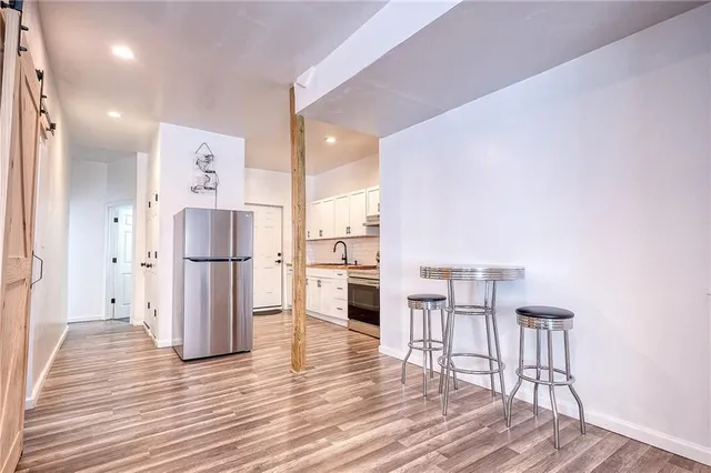 a kitchen with stainless steel appliances a refrigerator and wooden floor