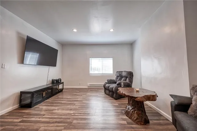 a living room with furniture flat screen tv and wooden floor